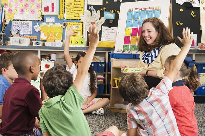 teacher teaching phonics to a class of elementary age students