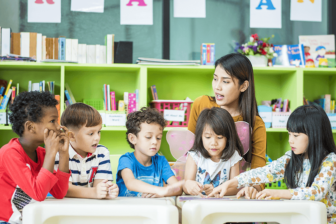 teacher teaching phonics to a group of elementary students