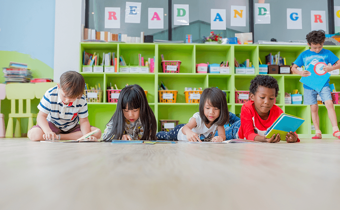 elementary students decoding text on floor of classroom